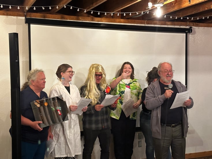 6 volunteers stand with props and costumes performing a play