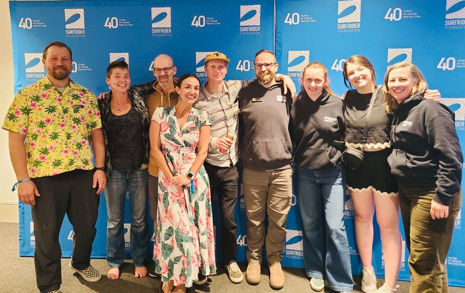 Washington staff and volunteers from the WA and Alaska network posing in front of a 40th anniversary backdrop