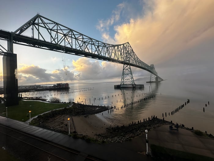 The Astoria bridge over the Columbia River with a cloudy susnset and calm water