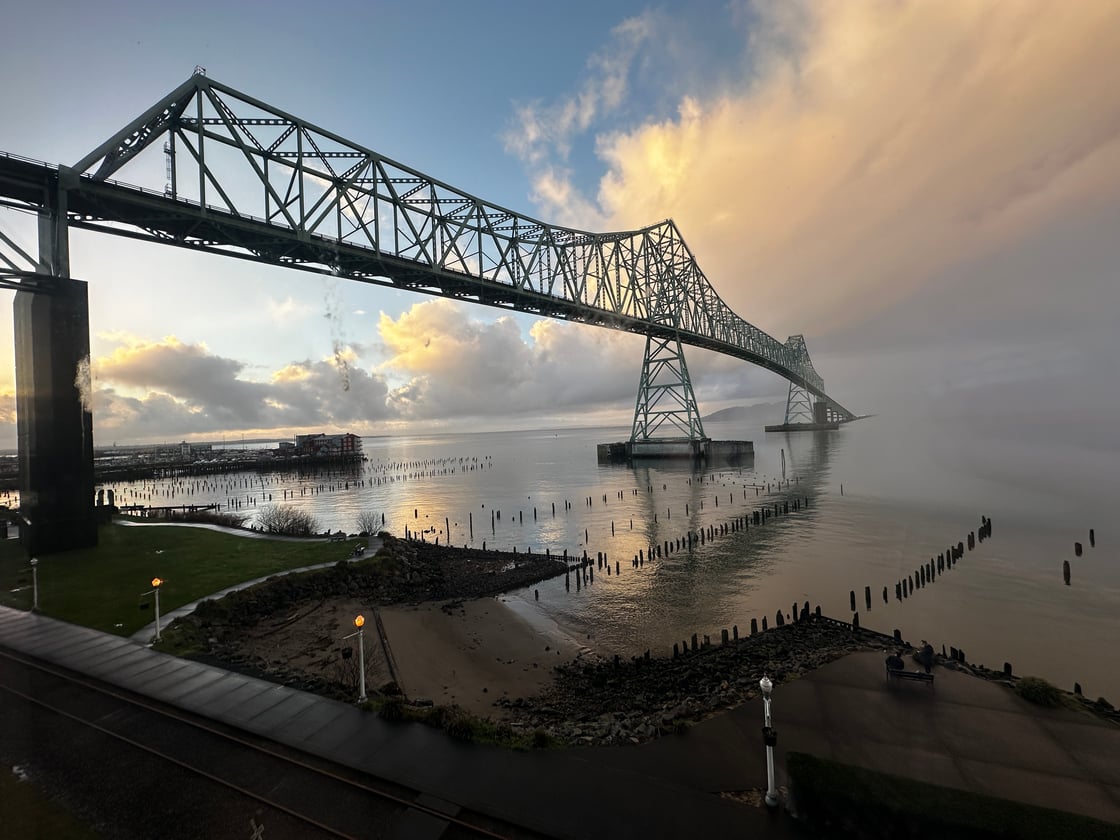 The Astoria bridge over the Columbia River with a cloudy susnset and calm water