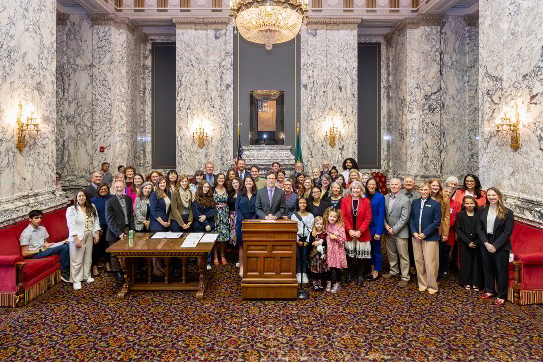 A group of activists standing in front of the podium at the bill signing for Washington's big EPR bill the Recycling Reform Act